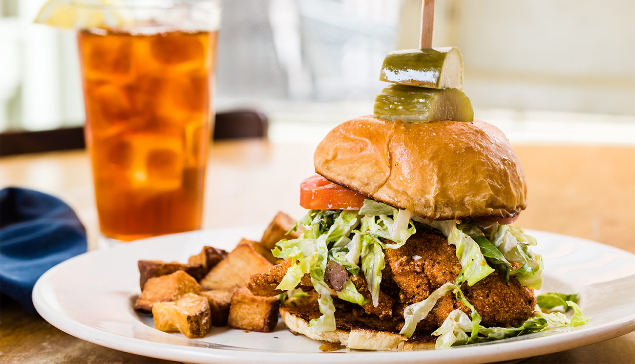 Hot fried chicken - chili oil, lettuce, aioli on brioche bun w/ house pickles.